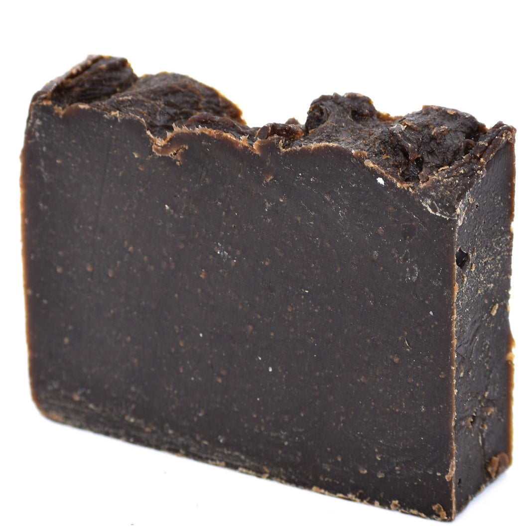 Dark brown bar of soap on a white background