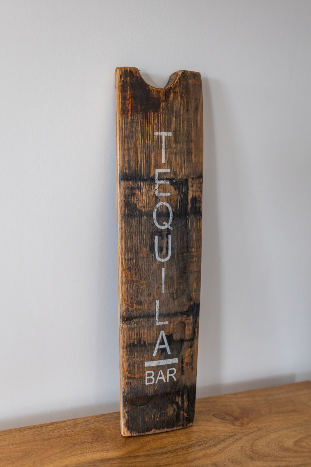 Wooden sign with 'Tequila Bar' text on a white wall