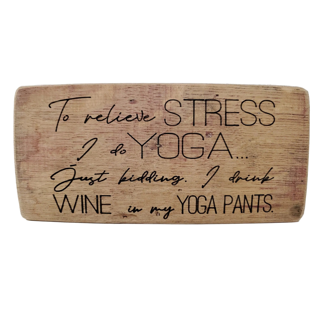 Wooden sign with humorous text about stress relief and wine drinking.