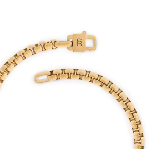Gold bracelet with a clasp on a white background
