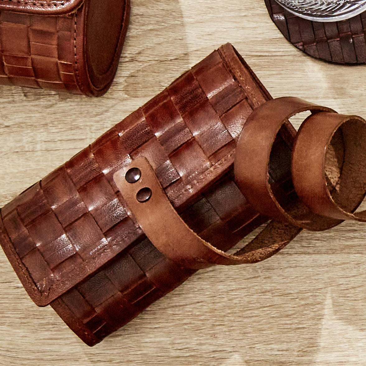 Brown woven leather roll-up watch case on a wooden surface