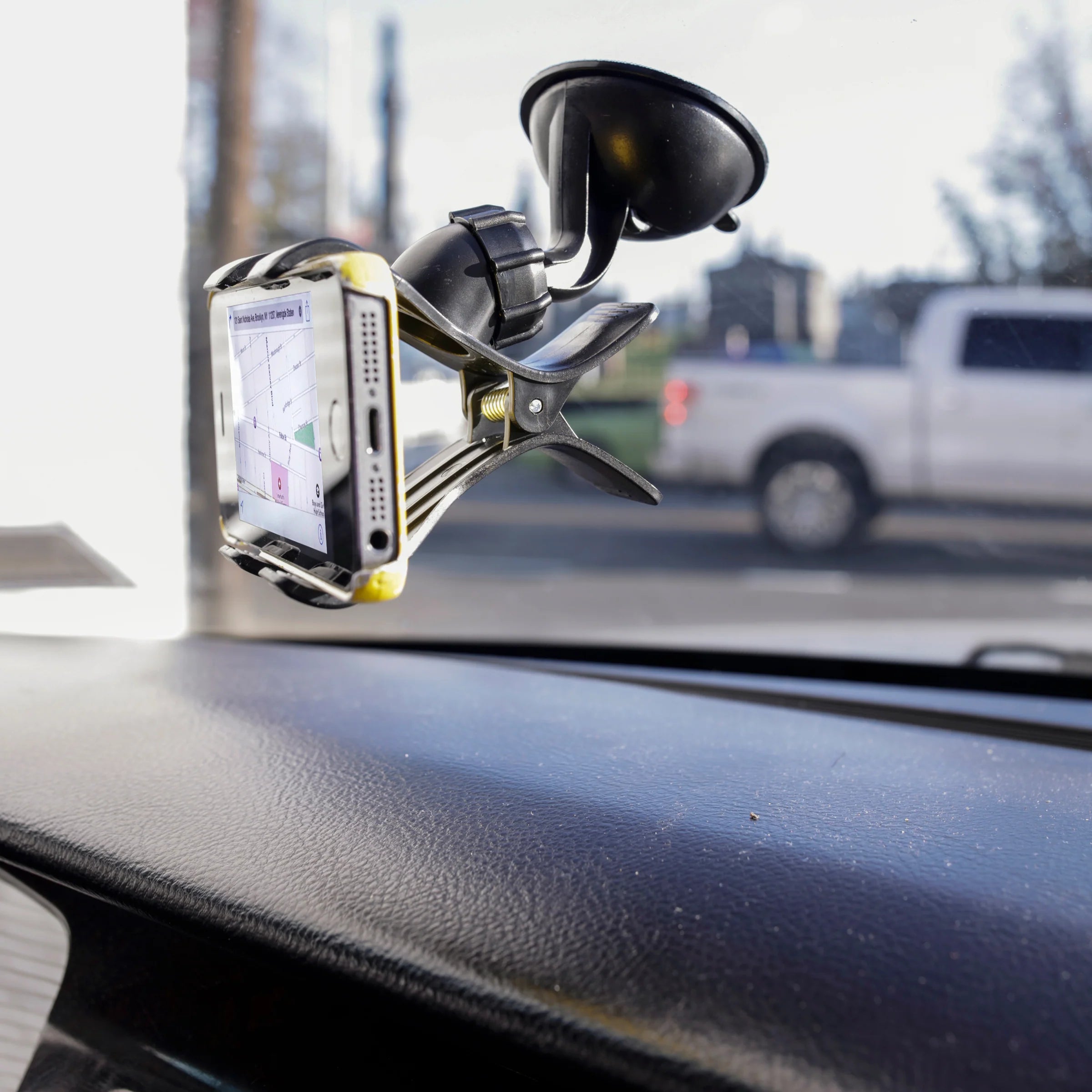 A phone in a mount in a car, attached to the windshield with a suction cup.