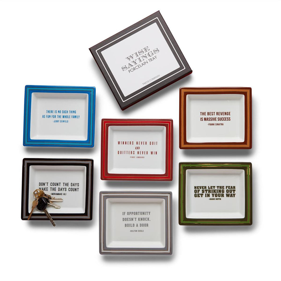 A collection of porcelain desk trays with various colorful frames and each featuring a different quote. They are displayed on a white background.