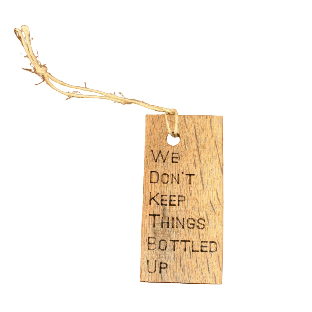 A wooden wine bottle tag with a rope attached, featuring text on it.
