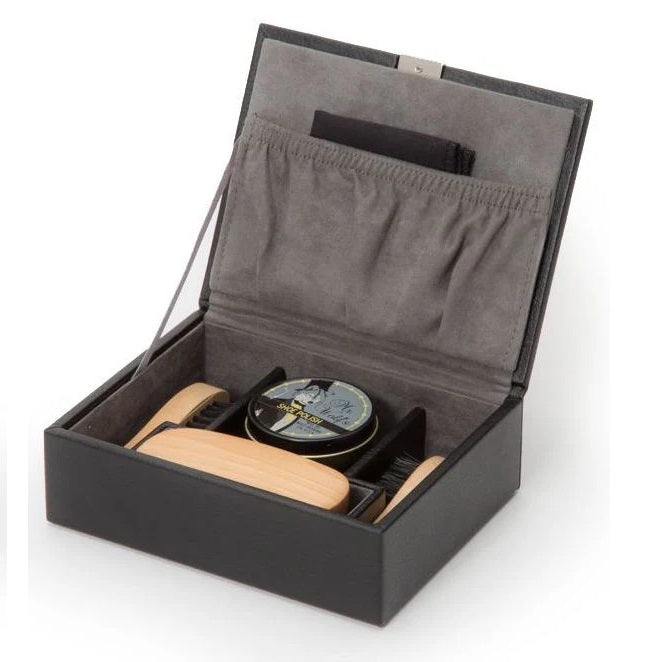 Shoe care kit with a container, brush, and cloths in an open black box on a white background