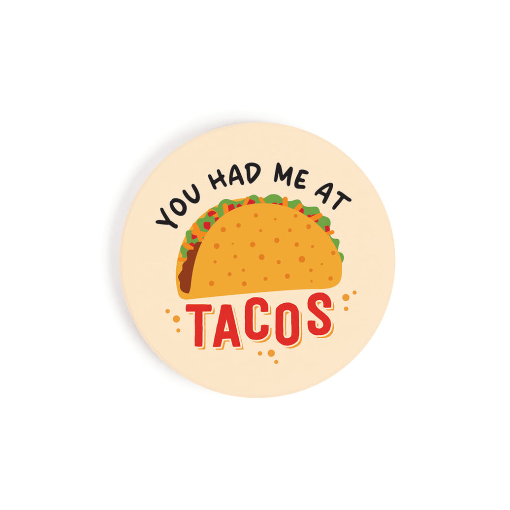 A circular car coaster with an image of a taco and 'you had me at tacos' on it, on a white background.