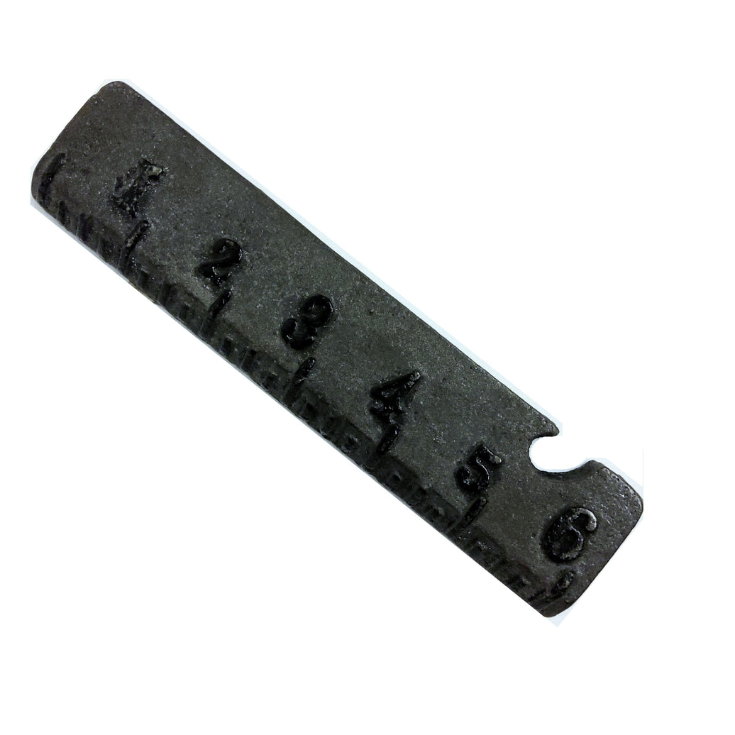 A black cast iron ruler bottle opener with measurement markings.