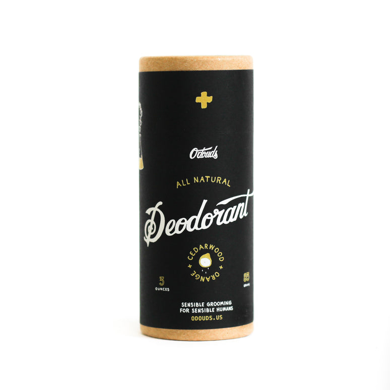 A black cylindrical container of O'Douds All Natural Deodorant with Cedarwood & Orange scent, featuring white and gold text on the label.