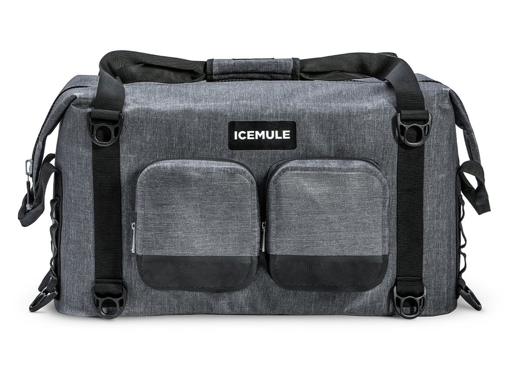 A gray Ice Mule Traveler soft cooler with a black top zipper and side straps, featuring a front pocket and the Ice Mule logo.