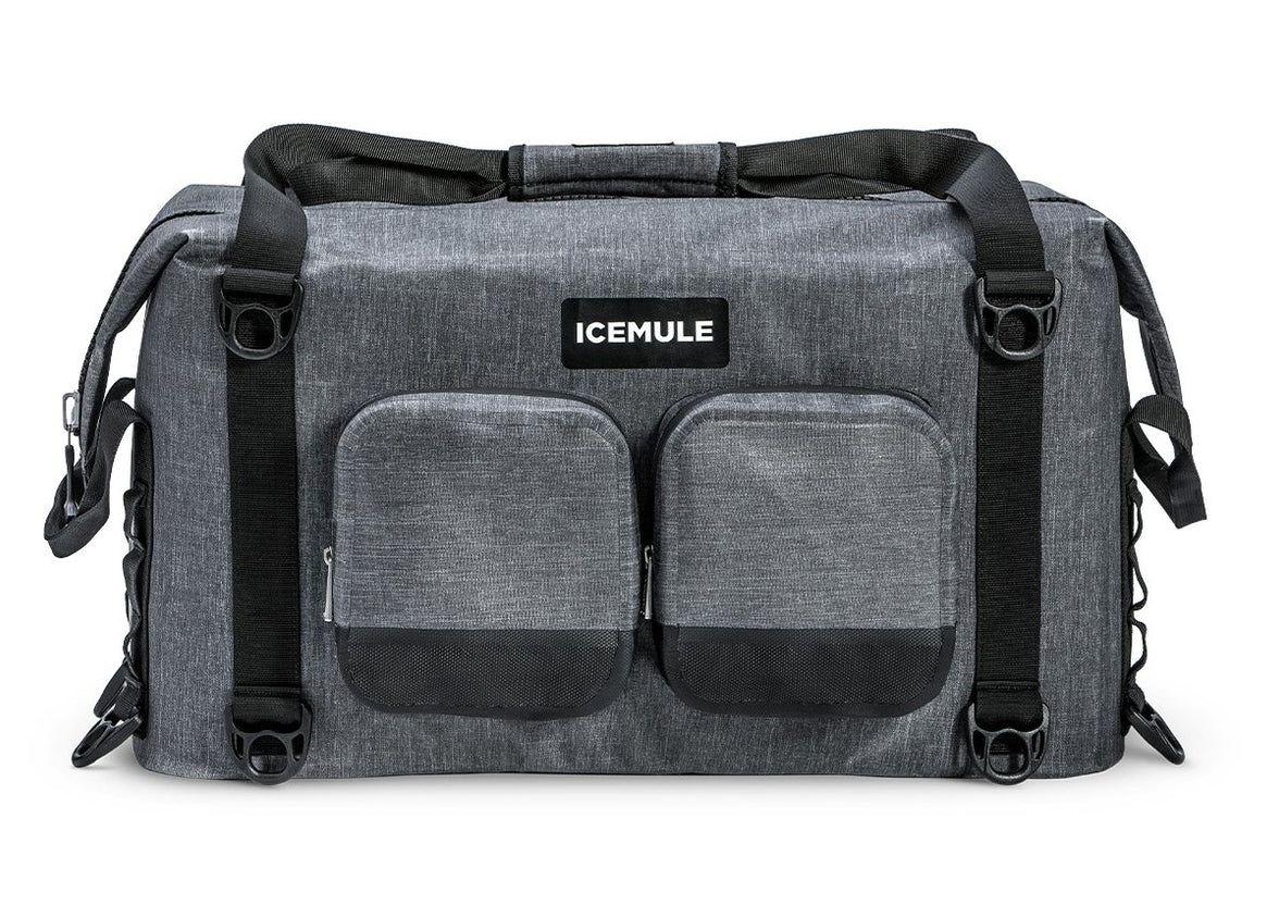 A gray Ice Mule Traveler soft cooler with a black top zipper and side straps, featuring a front pocket and the Ice Mule logo.