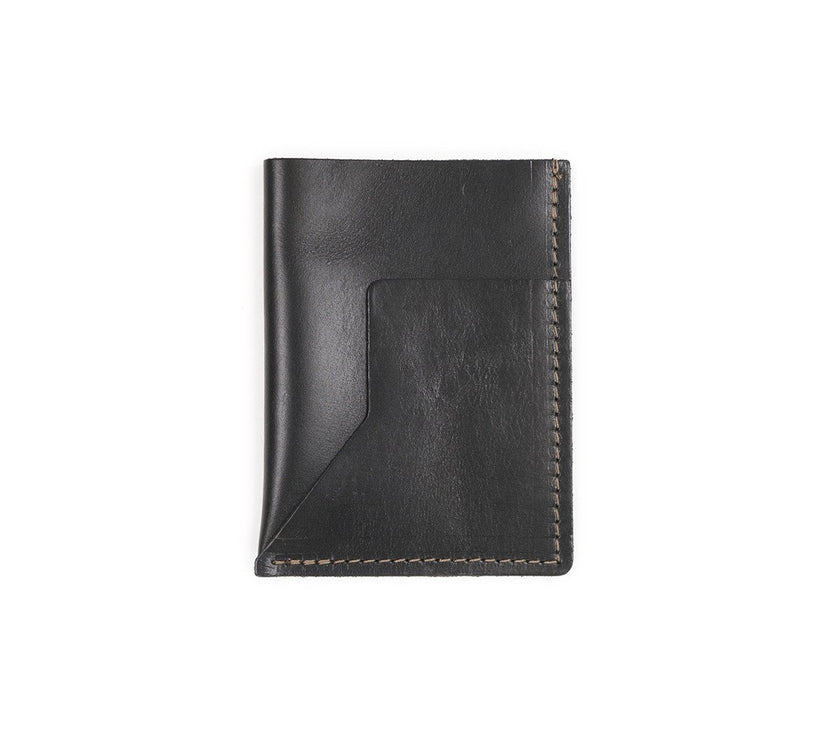 A black leather passport sleeve on a white background.