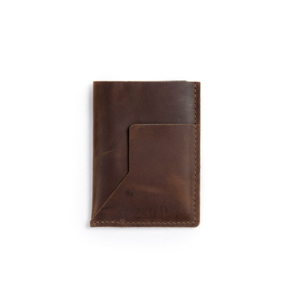 A brown leather passport sleeve on a white background.