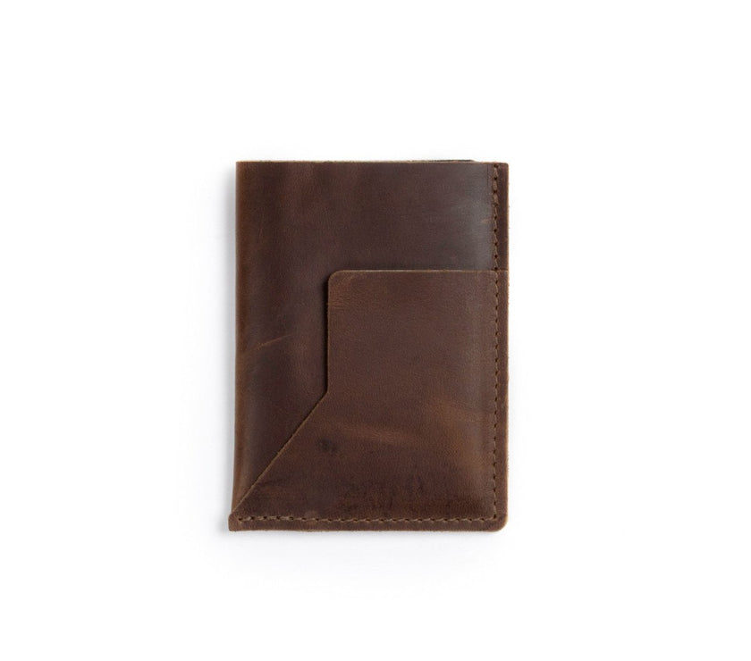 A brown leather passport sleeve on a white background.