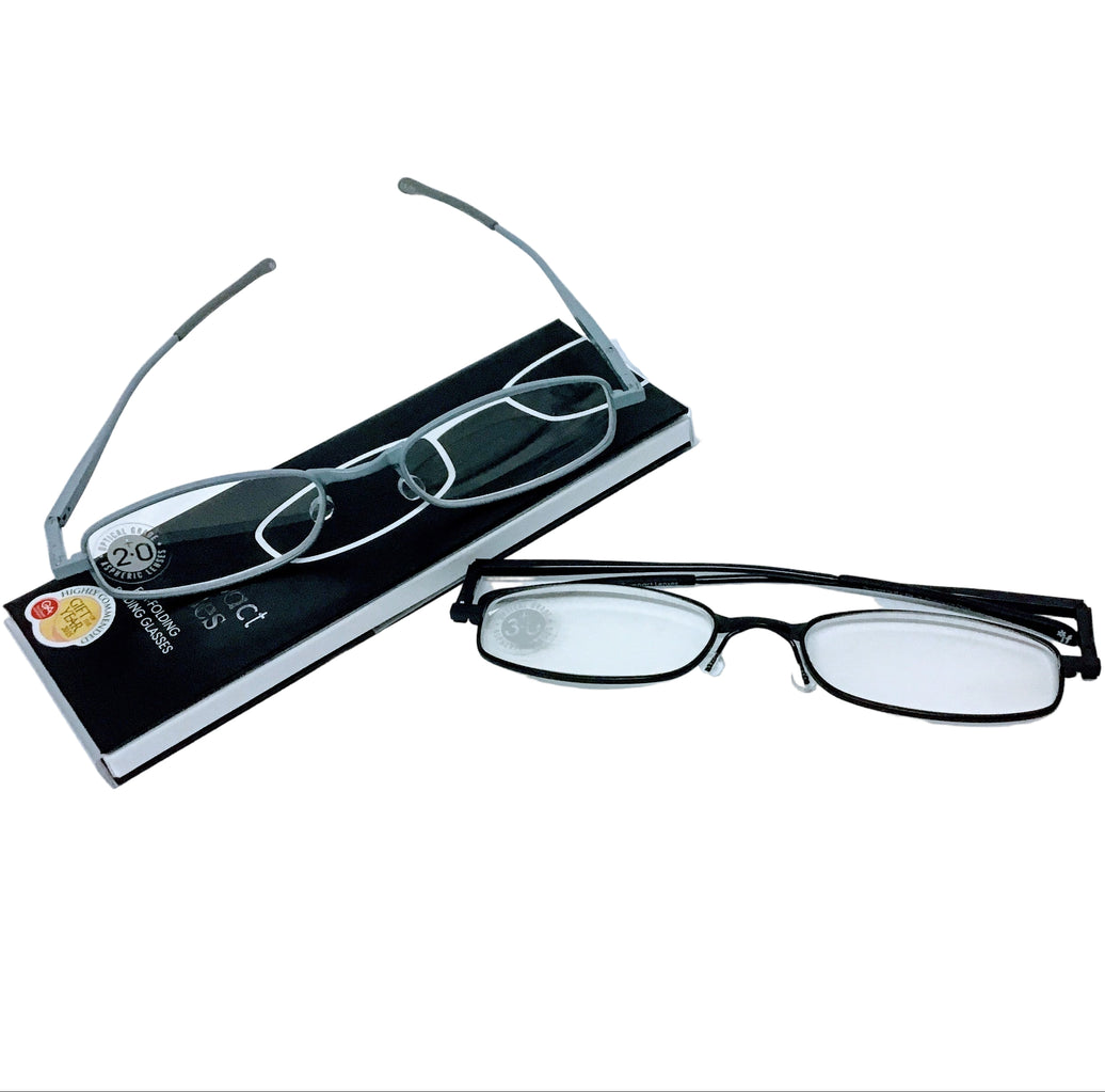 A pair of compact folding reading glasses with a metallic frame, displayed next to its packaging.