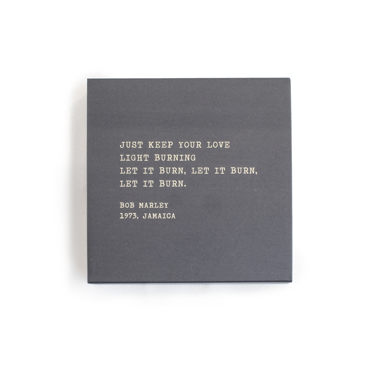A box of matches with a gray background and a quote by Bob Marley written on it.