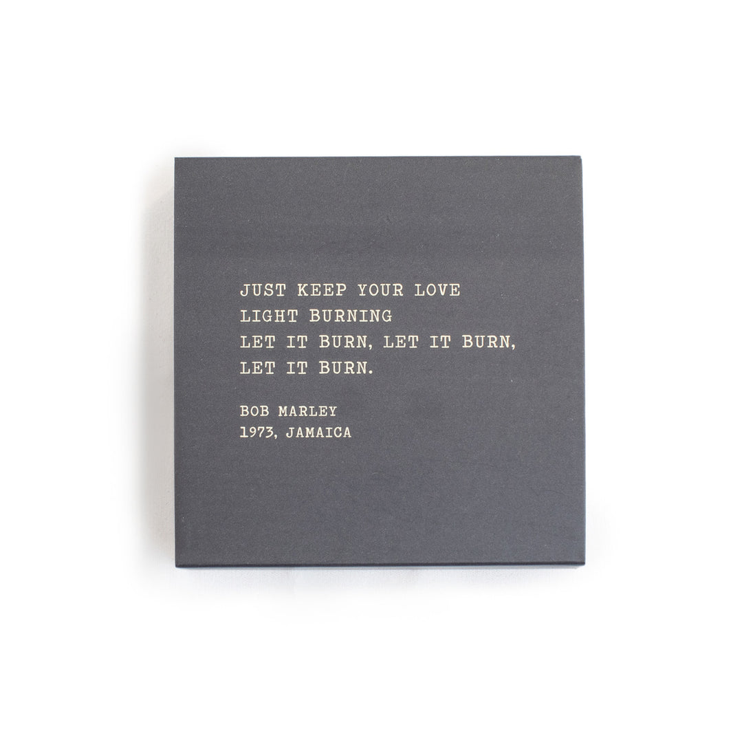 A box of matches with a gray background and a quote by Bob Marley written on it.