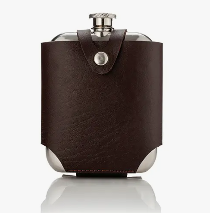 A stainless steel flask encased in a brown leather travel case.