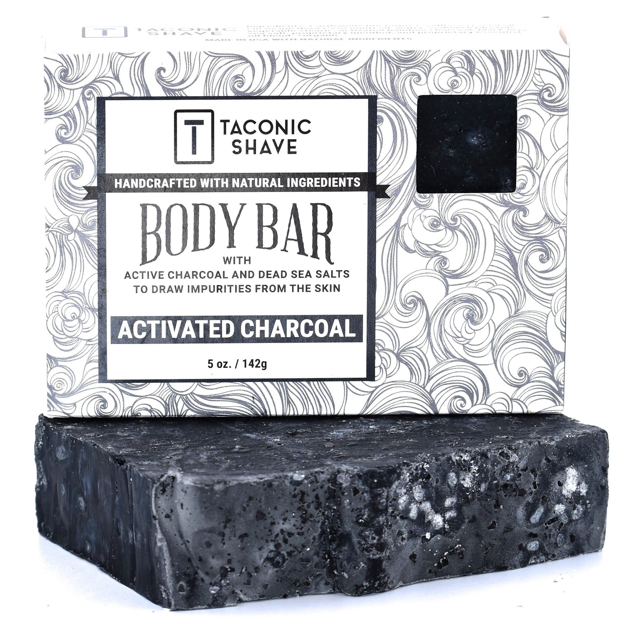 A packaged Taconic Body Soap Bar with activated charcoal, showing the bar of soap and its packaging with a swirl pattern and product information.