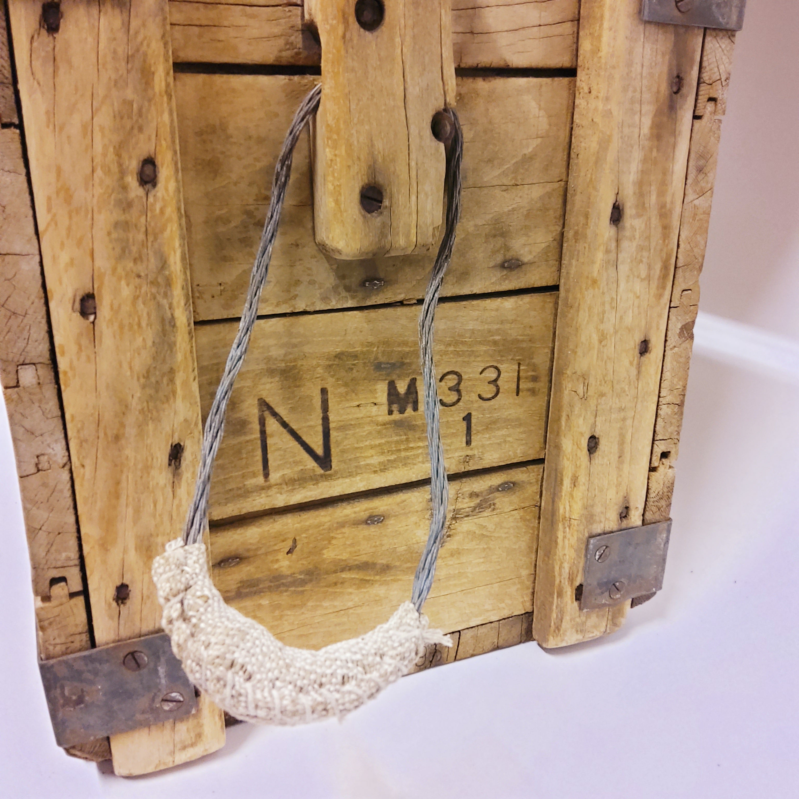 A closer look at the wide of an old wooden wine crate and one of its handles.