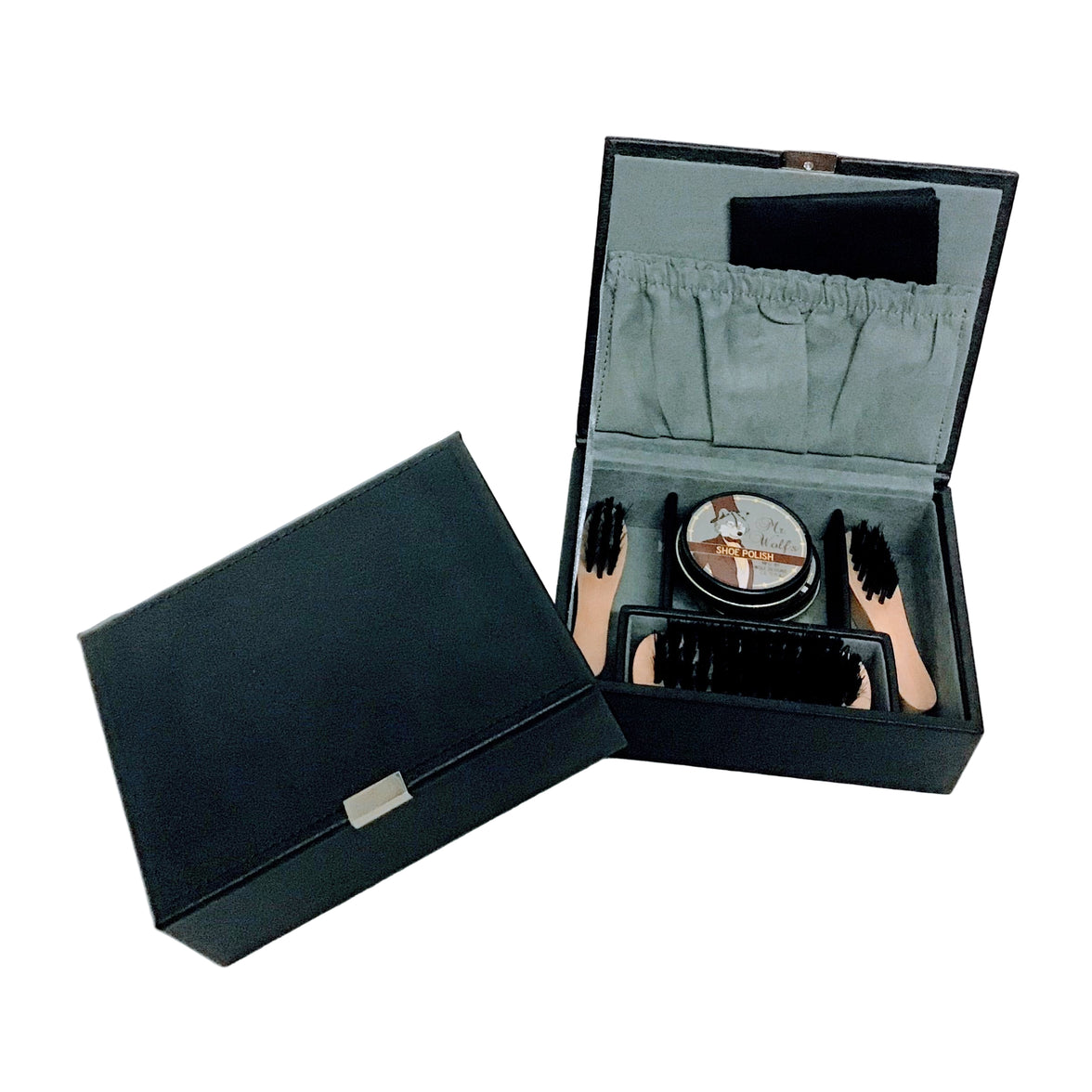 Shoe care kit with a container, brush, and cloths in an open black box beside a closed black box on a white background